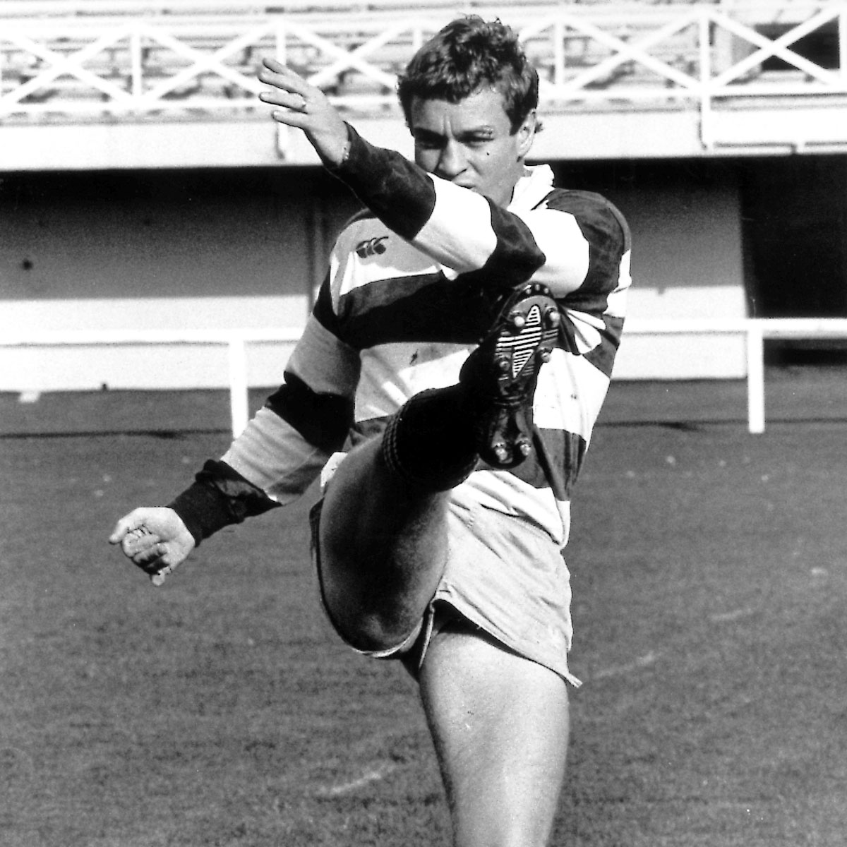 Black and white photo of Grant Fox making a kick